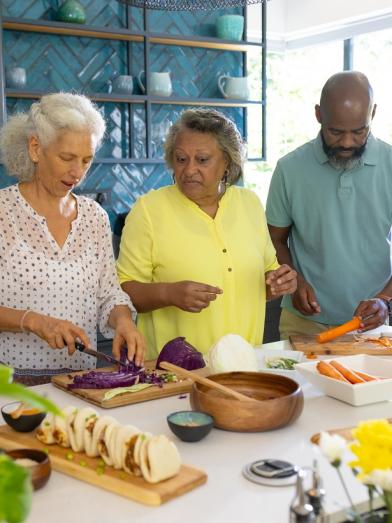 A group of people creating healthy cultural foods for a diabetes friendly meal to share