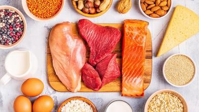 An assortment of protien rich foods like chicken, steak, salmon, almonds, eggs, and nuts. 