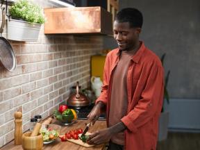A man preparing a solo meal for himself that is healthy and diabetic friendly with veggies