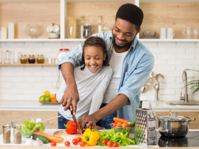 A father and daughter cut up veggies for a heart healthy and diabetes friendly diet