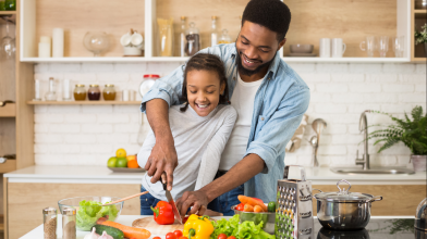 A father and daughter cut up veggies for a heart healthy and diabetes friendly diet