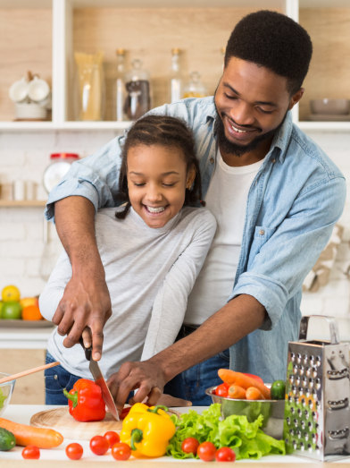 A father and daughter cut up veggies for a heart healthy and diabetes friendly diet