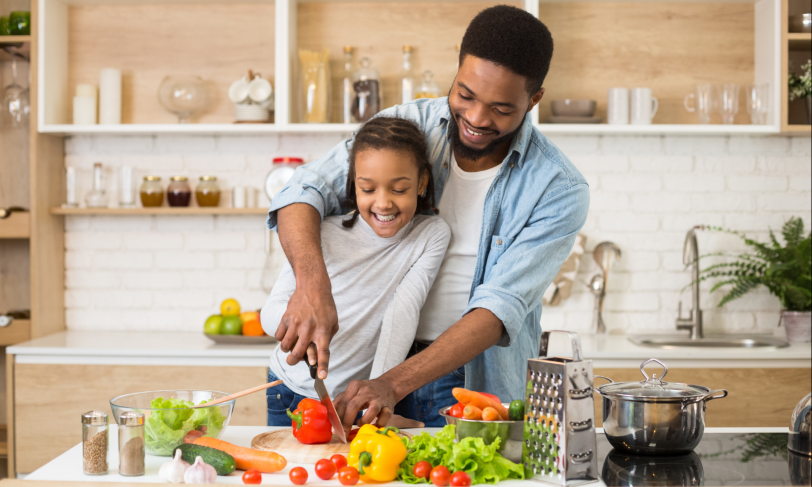 A father and daughter cut up veggies for a heart healthy and diabetes friendly diet
