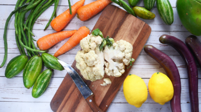 A chopping board with cauliflower surrounded by veggies perfect for a healthy diabetic diet